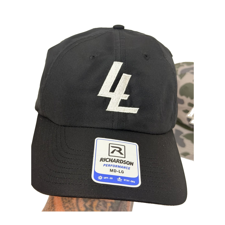 Translation missing: en.A black Richardson MD-LG baseball cap featuring a white embroidered 'LL' logo on the front and a white and blue Richardson Performance sticker on the brim, shown against a white background