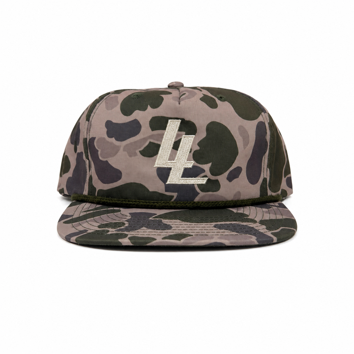 Translation missing: en.A flat-brim snapback cap in a muted camouflage pattern of beige, olive green, and dark gray, featuring an embroidered LL  logo on the front