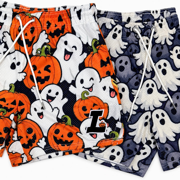 Translation missing: en.Two pairs of Halloween-themed mesh drawstring shorts laid flat on a white background. The left pair features orange jack-o'-lanterns and white ghosts on a black background, with a large letter 'L' logo on bottom left leg