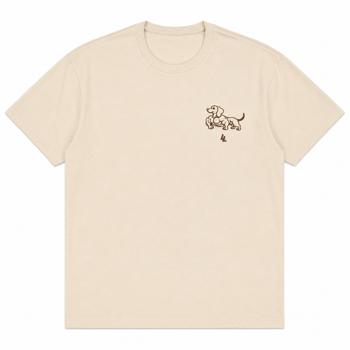 Translation missing: en.A cream-colored short-sleeve crewneck t-shirt with a small brown line-art graphic of a dachshund on the left chest, displayed on a clean white background
