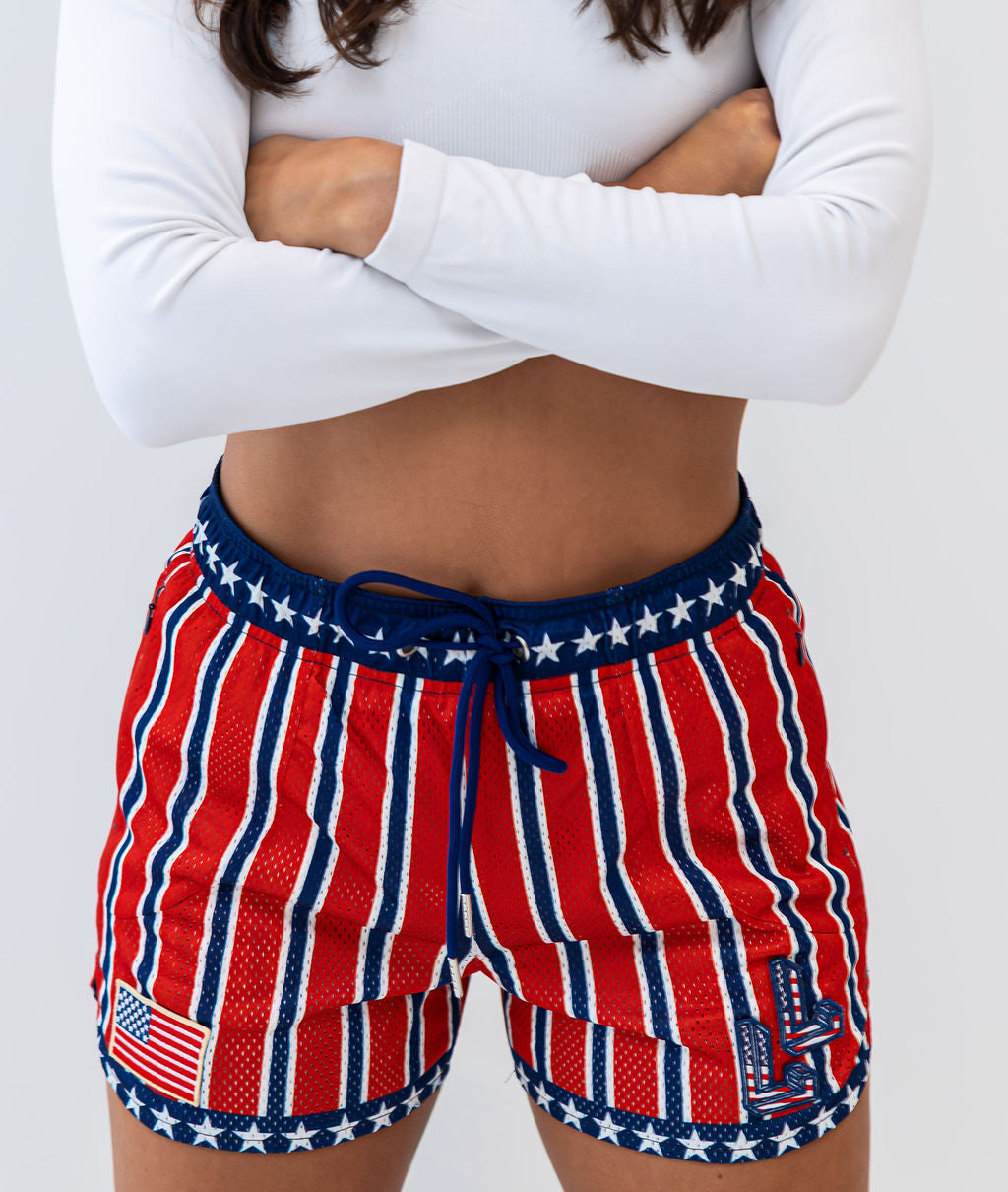 Person wearing red, white, and blue striped shorts with star patterns on a plain background