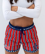 Person wearing red, white, and blue striped shorts with star patterns on a plain background