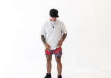 Man wearing a white t-shirt and red, white, and blue shorts on a white background